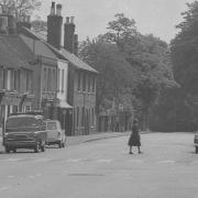 A woman crosses the road in this peaceful scene in Kings Langley from 1963