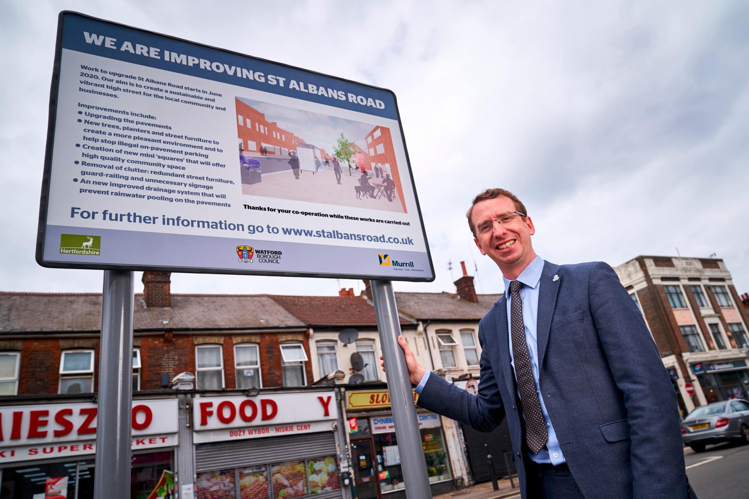 Watford mayor Peter Taylor pictured by a sign outining the ongoing improvements for St Albans Road