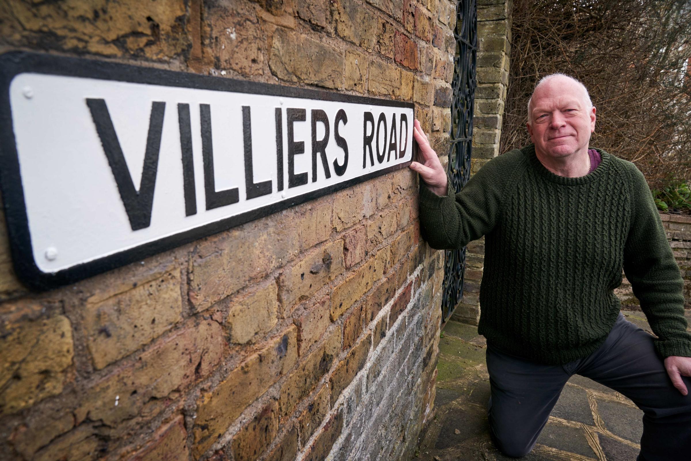 Councillor Stephen Giles-Medhurst standing by the restored Villiers Road street sign