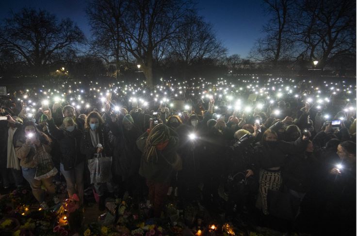Crowds at the vigil shine their lights on their mobile phones as clashes broke out. Credit: PA