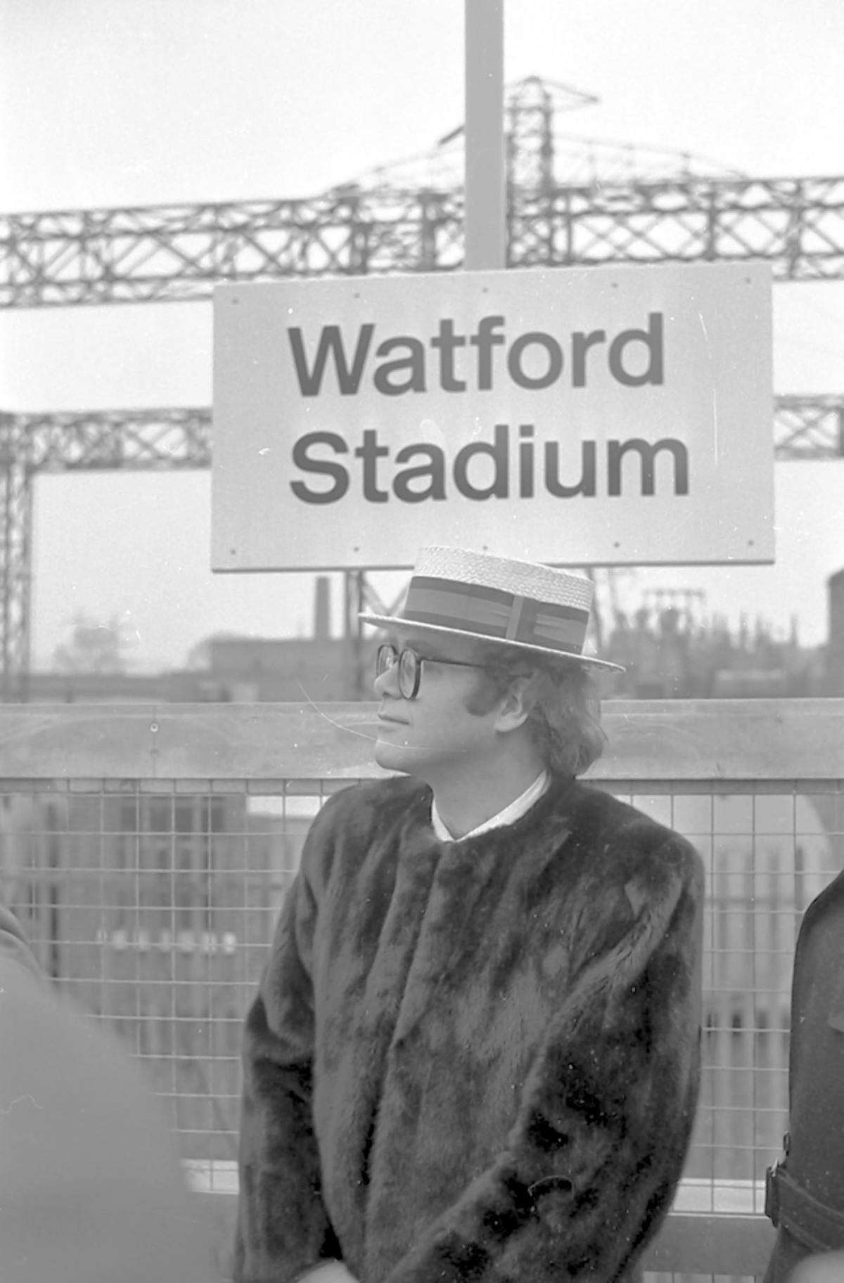 The rock star chairman beneath the Watford Stadium sign