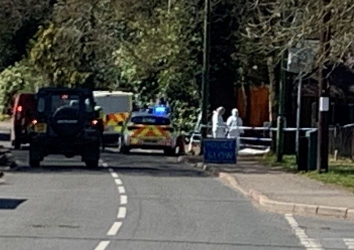 Two forensic officers can be seen in Hazel Road at the junction of Park Street Lane