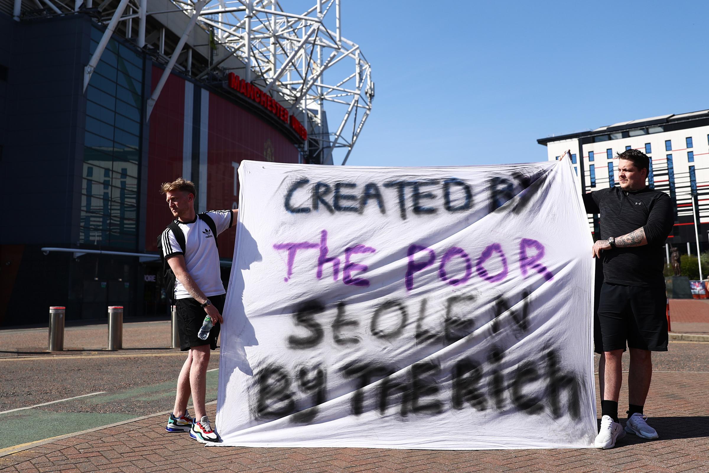 Football fans opposing the European Super League outside Old Trafford in Manchester. Credit: PA