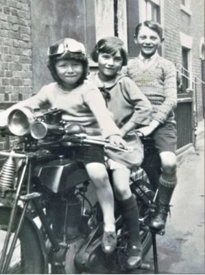 Les, left, pictured with his sister Pauline and brother Sidney on a bike during their childhood