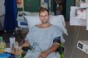 Liam Coffill, a fire fighter who works at Garston Fire Station, in hospital only days after his operation.