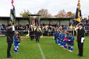 Youngsters from Oxhey Jets Youth help form a guard of honour for the dignitaries and teams at the Remembrance Match