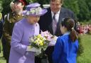 The Queen receives a bouquet from a child during a more recent visit to Hatfield House
