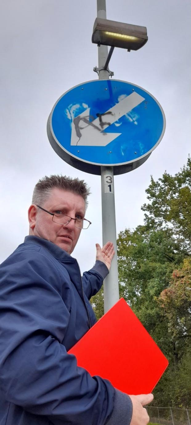 Watford Observer: Cllr Steve Cox pictured by the graffitied road sign on November 4