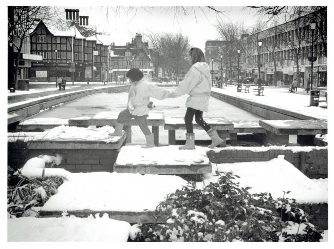 Two girls climb across the edge of the pond in February 1994. Pictures: Watford Museum