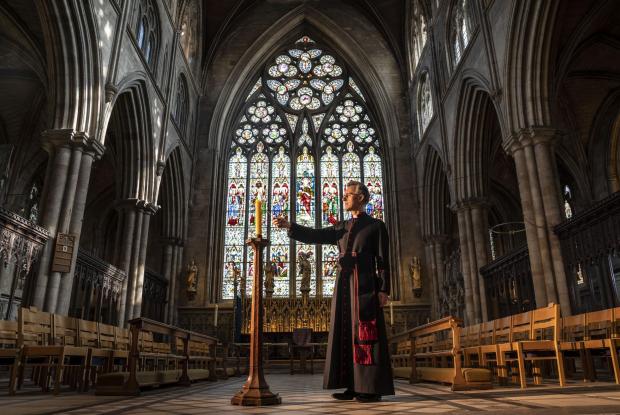Watford Observer: Very Reverend John Dobson Dean of Ripon lights a candle to mark the second anniversary of the first national coronavirus lockdown at Ripon Cathedral, North Yorkshire, ahead of the National Day of Reflection on Wednesday (PA)