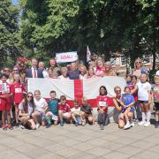 England legend Kelly Smith, players from Watford FC's women’s team and young footballers raise the England flag outside Watford town hall with Watford's mayor ahead of the women's Euros final on Sunday. Credit: Watford Borough Council