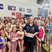 Josie Hoare with her award and some of the Watford swimmers she has helped to coach. Image: Watford Swimming Club
