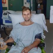 Liam Coffill, a fire fighter who works at Garston Fire Station, in hospital only days after his operation.