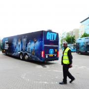 The Man City bus heads off from Watford Junction.